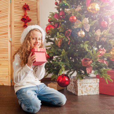 Noel ağacının yanında hediyeli bir çocuk