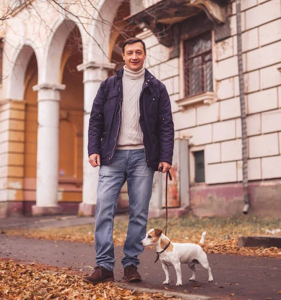 Человек гуляет со своей собакой — стоковое фото