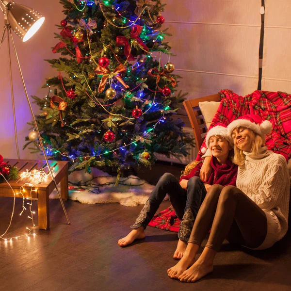 Smiling girl with mom near christmas tree at home — Stock Photo, Image