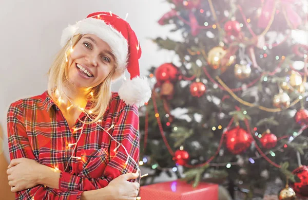 Glückliche Frau in Weihnachtsbeleuchtung gehüllt — Stockfoto