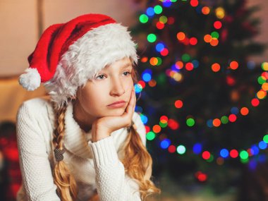 Evdeki Noel ağacının yanında üzgün bir kız