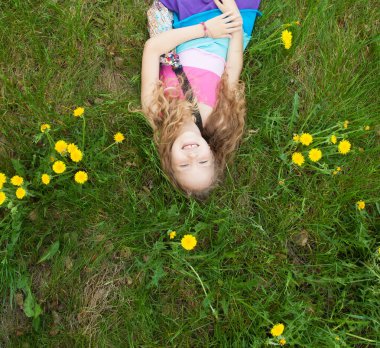 Yazın çocuk. Yeşil çimlerin üzerinde mutlu bir kız