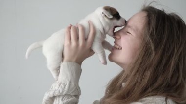 Küçük bir köpekle oynaşan ve oynaşan bir kız.