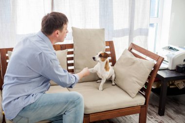 Evde köpekli bir adam var. Sevdiği hayvanıyla yetişkin bir adam.