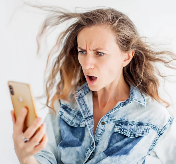 驚いた女性は携帯電話を見て ショックを受けた女の子とともにスマートフォン — ストック写真