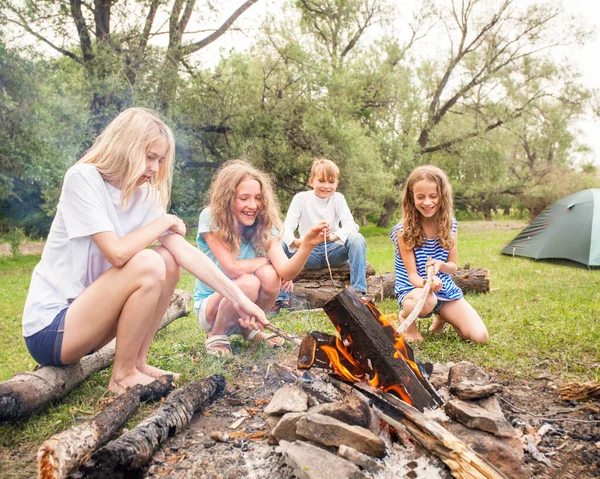 キャンプファイヤーキャンプで子供たちのグループ 少年たちはたき火の近くの森の中でリラックス — ストック写真