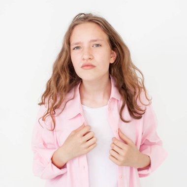 Doğal genç kız, kameraya dön ve neşeli görün, pembe gömlekli beyaz arka planda dur. Tedbirli genç öğrencinin portresi