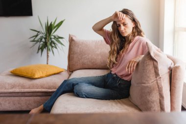 Sorunları düşünen üzgün bir kadın, evde tek başına oturuyor, psikolojik sorunları var. Kadın duygusal stresi