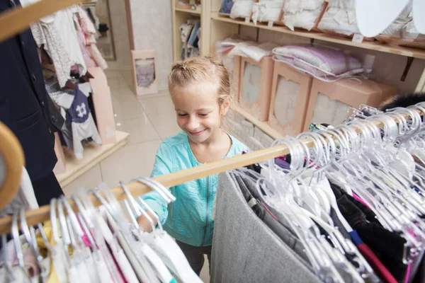 Çocuk Mağazasında Bir Çocuk Mutlu Kız Kıyafet Seçiyor — Stok fotoğraf