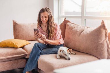 Gülümseyen kadın rahat ol ve cep telefonunu tut. Çevrimiçi alışveriş akıllı telefon kullanarak mutlu kadın cep telefonuyla konuşuyor