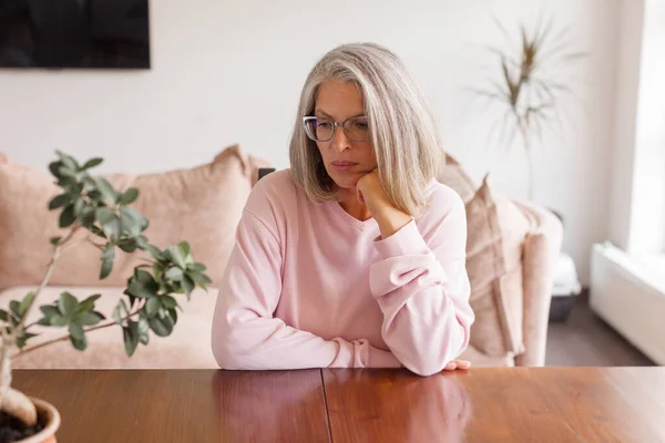 Грустная Задумчивая Женщина Среднего Возраста Смотрящая Вниз Депрессии Сидя Столом — стоковое фото