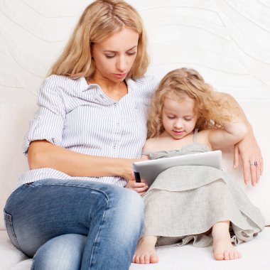 Anne ve kızı kanepe, tablet ile