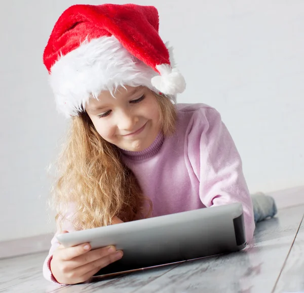 Niño en sombrero de Navidad con tableta — Foto de Stock