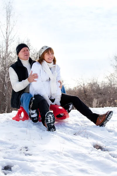 Mature couple sledding — Stock Photo, Image