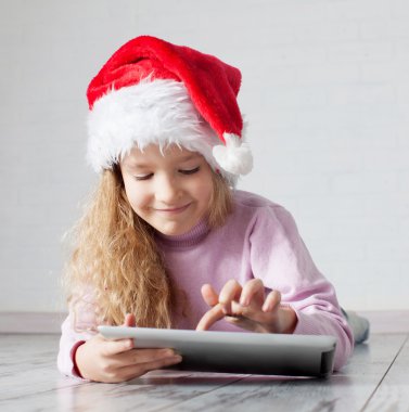 tablet ile Noel şapkalı çocuk