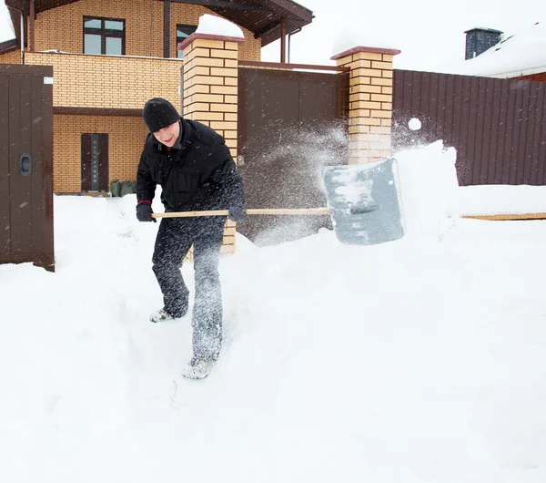 Mann räumt Schneeschaufeln — Stockfoto