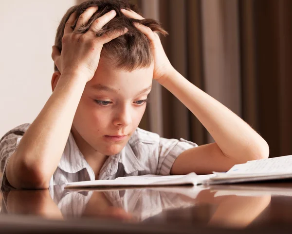 Menino triste fazendo lição de casa — Fotografia de Stock