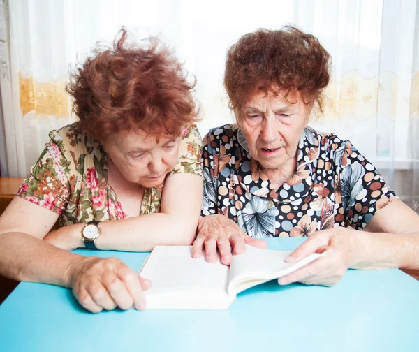 Dos personas mayores leyendo el libro — Foto de Stock