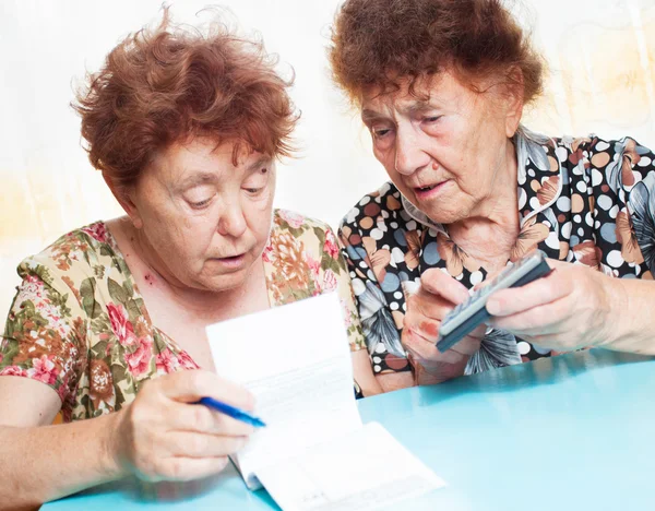Twee oude vrouwen overwegen ontvangsten — Stockfoto