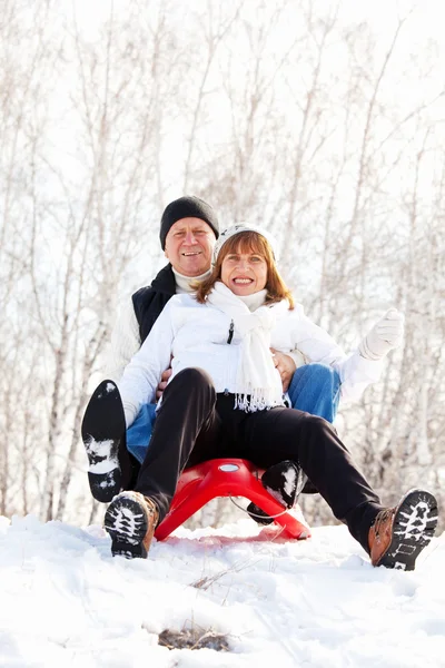 Mature couple sledding — Stock Photo, Image