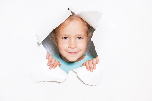 Ребенок смотрит из отверстия в бумаге — стоковое фото