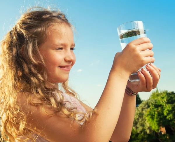 Flicka anläggning glas med vatten — Stockfoto