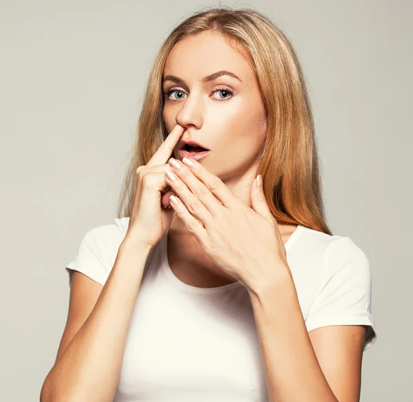 Kobieta wybiera palca swego nosa — Zdjęcie stockowe