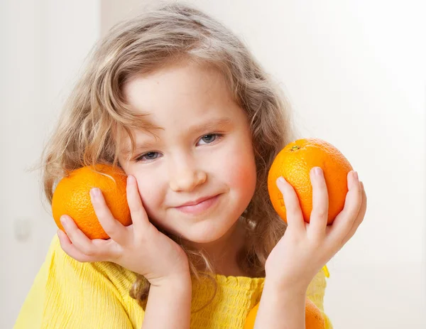 Kind mit Orangen — Stockfoto