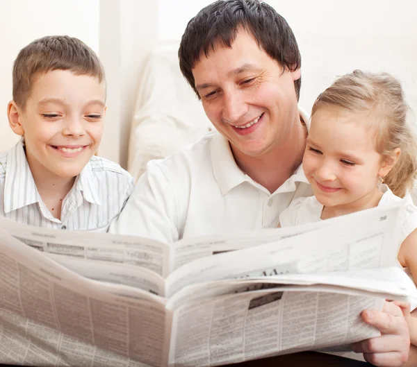 Família lendo um jornal — Fotografia de Stock