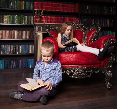 Çocuklar evde kitap okuyor.