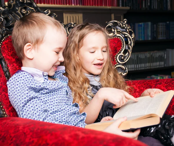 Bambini che leggono libro a casa — Foto Stock