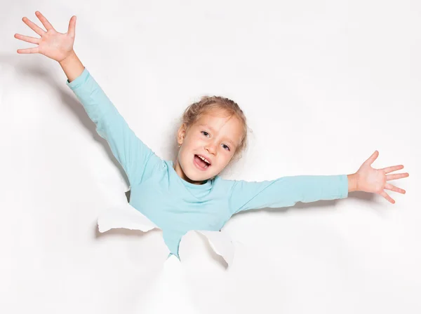 Kind op zoek uit een gat in papier — Stockfoto