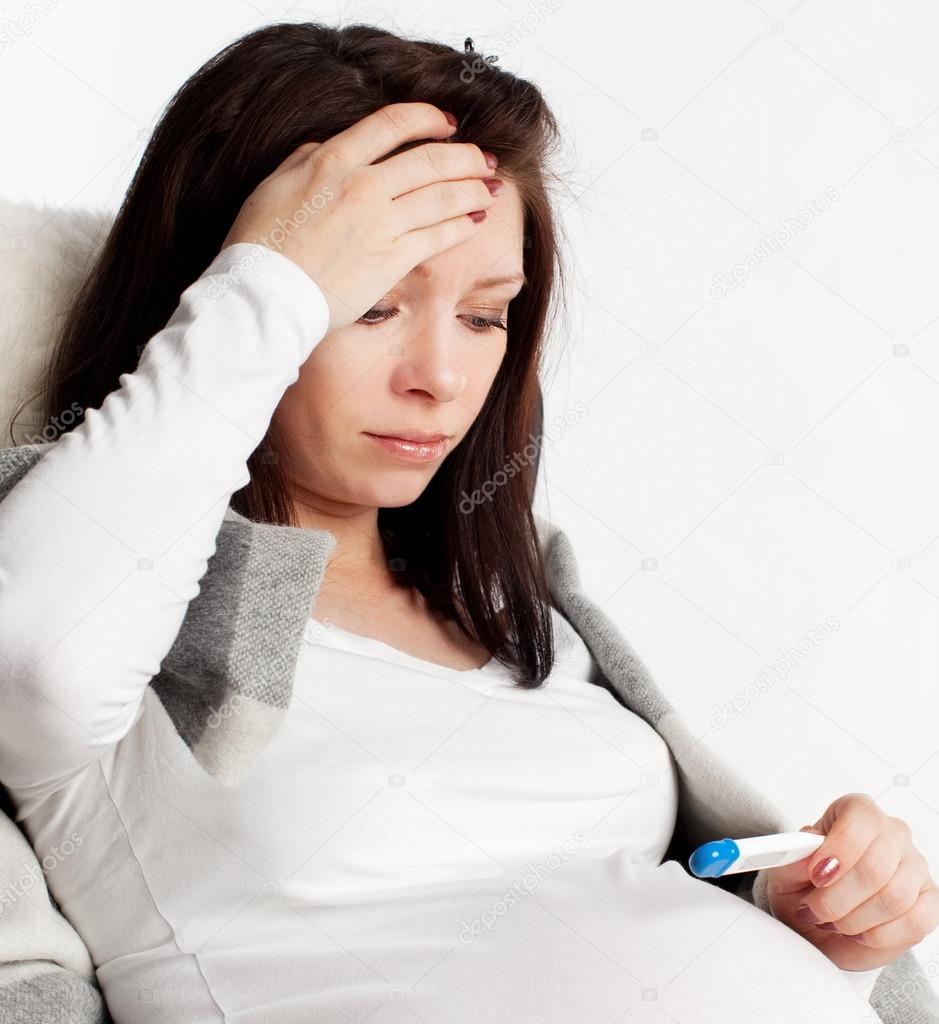 Pregnant woman with a thermometer
