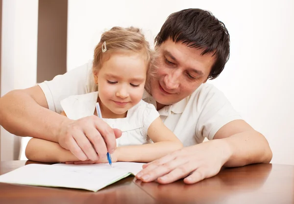 Padre ayudando a hija a hacer la tarea — Foto de Stock