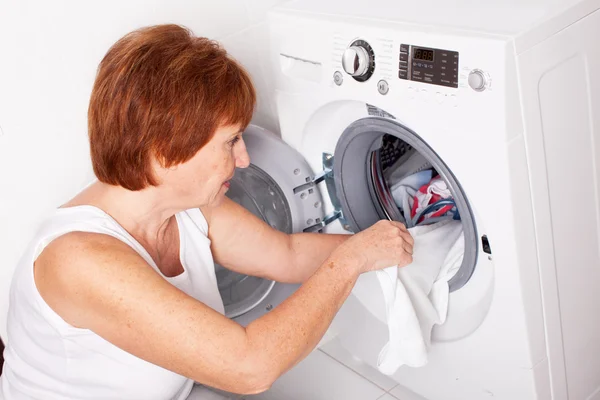 Vrouw zet kleren in de wasmachine — Stockfoto