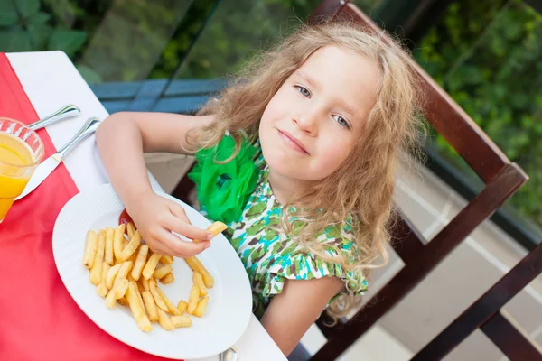 Сhild eating potato chips in the cafe — Stock Photo, Image