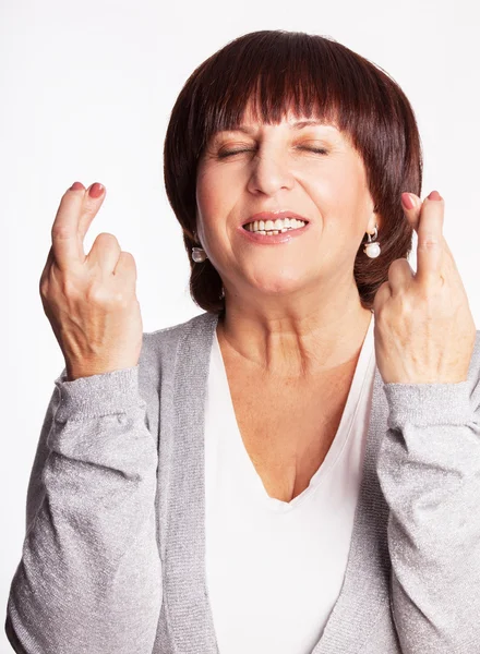 Volwassen vrouw met gekruiste vingers — Stockfoto