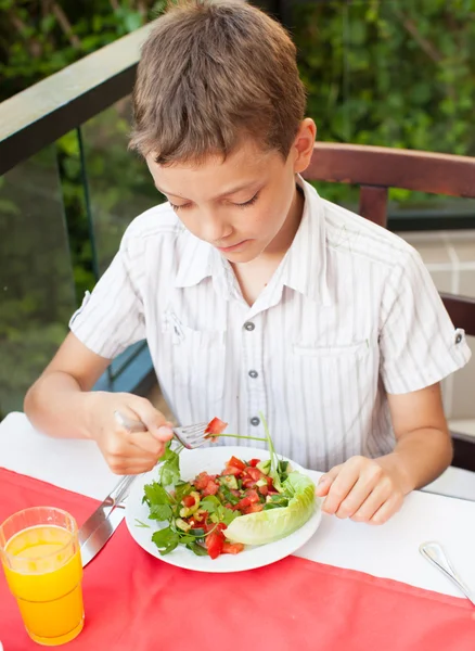 Bambino mangiare insalata in un caffè — Foto Stock