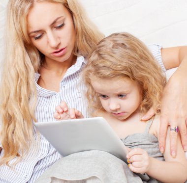 Anne ve kızı kanepe, tablet ile