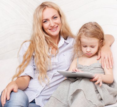 Anne ve kızı kanepe, tablet ile