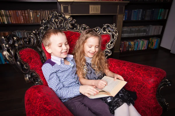 Niños leyendo libro en casa — Foto de Stock