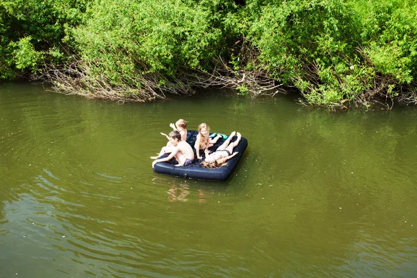 Niños flotando en el río — Foto de Stock