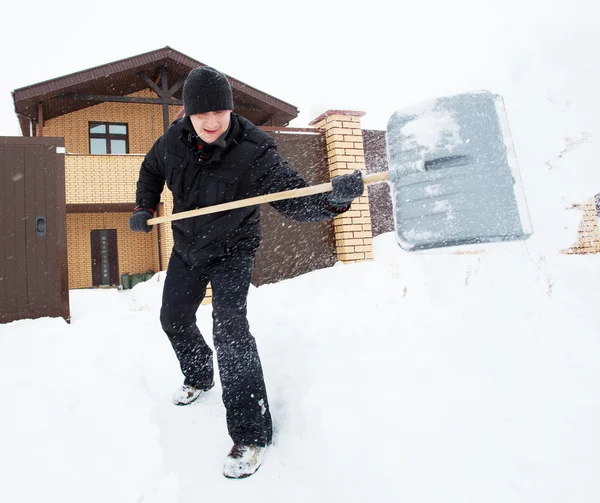 Man cleans snow shovel — Stock Photo, Image