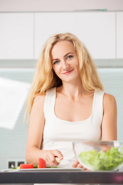 Jovem mulher preparando salada vegetal — Fotografia de Stock