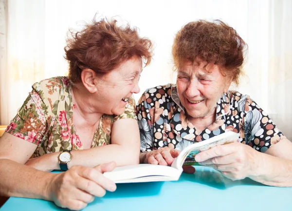 Два пожилых человека читают книгу — стоковое фото
