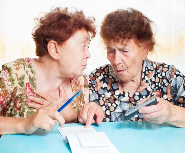 Twee oude vrouwen overwegen ontvangsten — Stockfoto