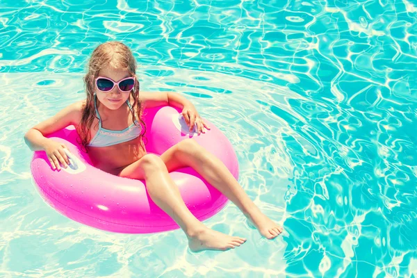 Meisje op opblaasbare ring in zwembad — Stockfoto