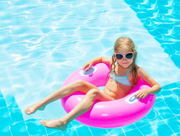 Menina no anel inflável na piscina — Fotografia de Stock