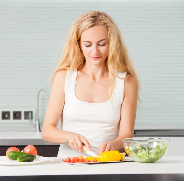 Junge Frau bereitet Gemüsesalat zu — Stockfoto