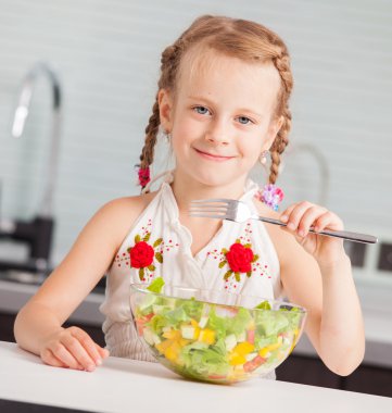 sebze salatası yiyen küçük kız